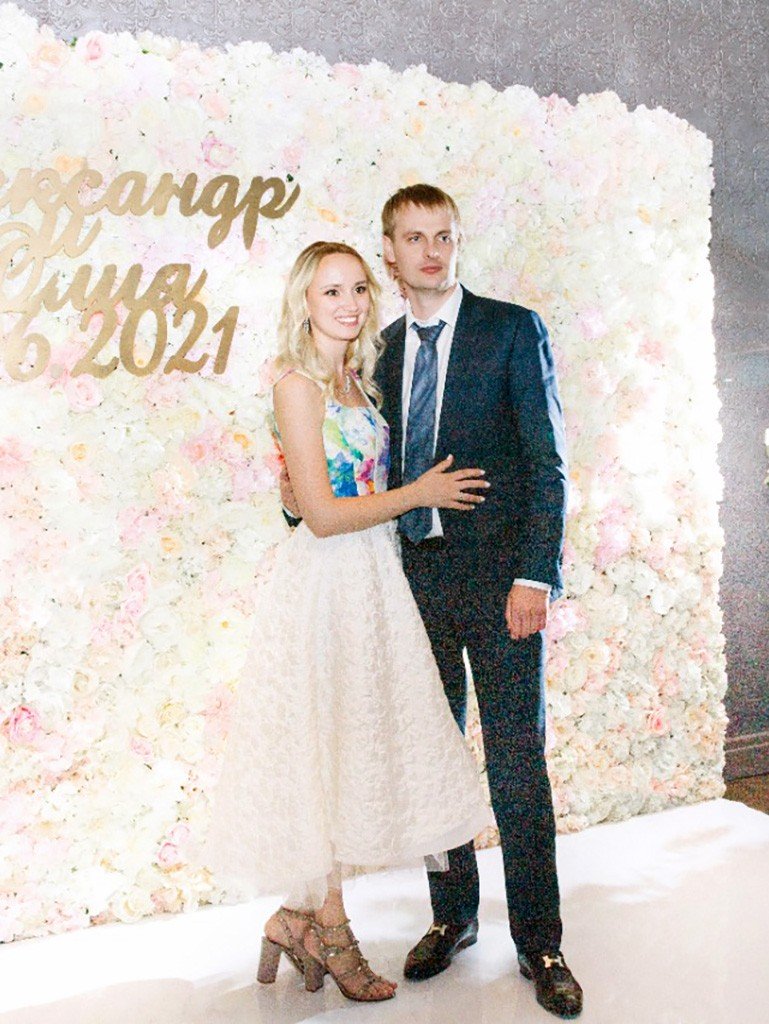 Девушка в свадебном платье с женихом на цветочном фоне